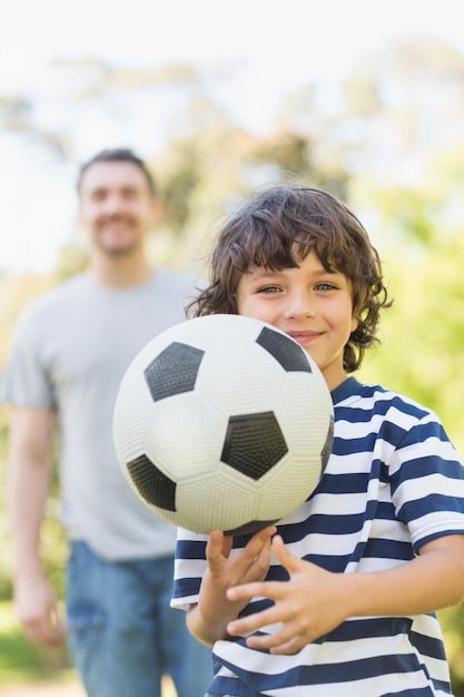 Vader en zoon voetballen in park