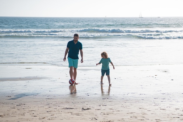 Vader en zoon voetballen of voetballen op het strand tijdens gezinsvakanties in de zomer, mannengeneratieconcept