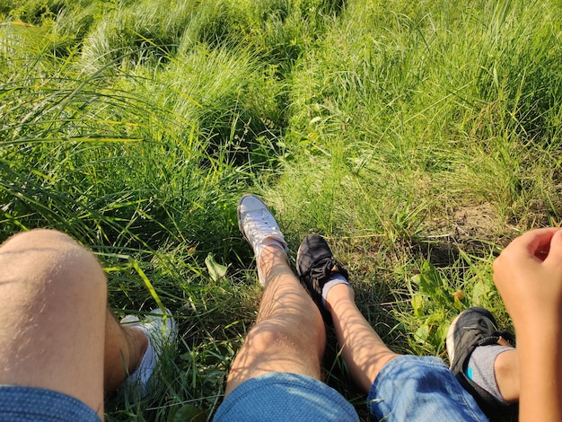 Vader en zoon voeten in het gras in het park