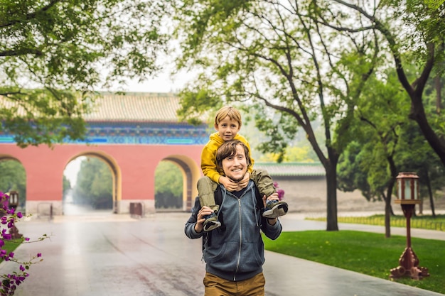 Vader en zoon zijn toeristen op de achtergrond van de grote Chinese poorten Reizen met kinderen in China concept