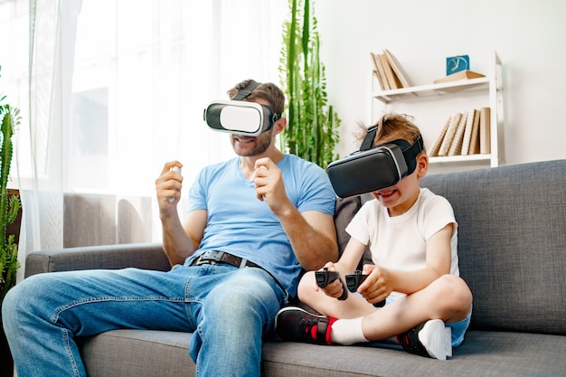 Vader en zoon zitten op de bank en spelen samen met een Vr-bril