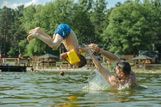 Vader gooit zoon in het water en heeft plezier