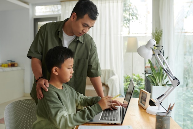 Vader helpt zijn tienerzoon met programmeren