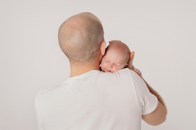 Vader houdt de baby in zijn armen.