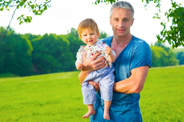 Vader houdt zijn zoon op handen vader en zoon op de natuur