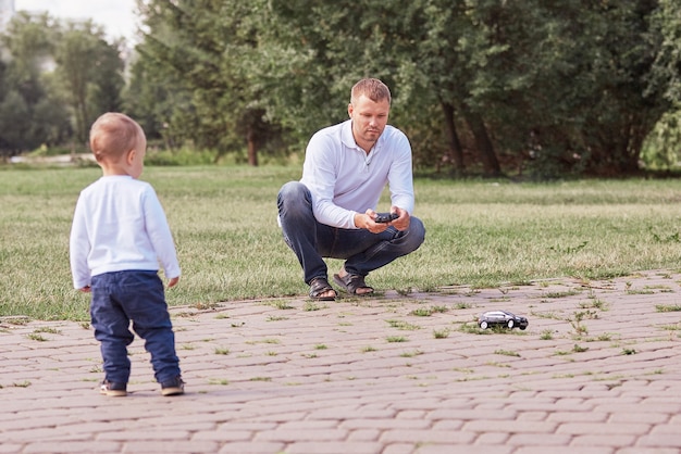 Vader kijkt naar zijn zoontje tijdens het wandelen in het park