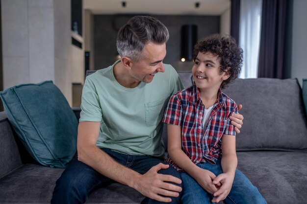 Vader knuffelt zoon die naar elkaar kijkt