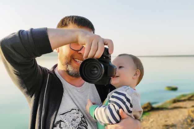 Vader laat de babyfoto's op de camera buiten zien