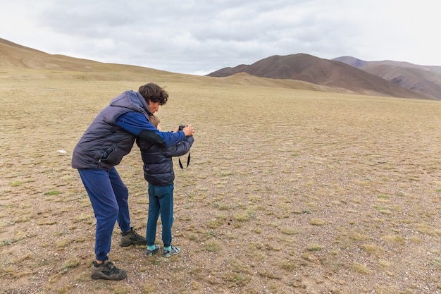 Vader leert zoon om foto's te maken in stepp van Mongoolse Altai.