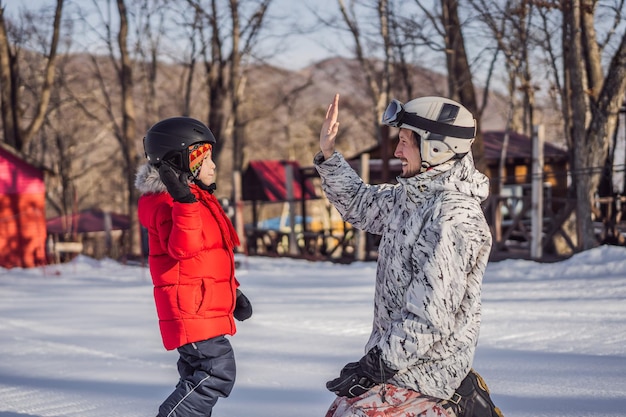 Vader leert zoon snowboardactiviteiten voor kinderen in de wintersportlevensstijl van kinderen