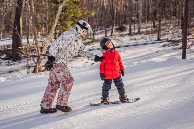 Vader leert zoon snowboarden Activiteiten voor kinderen in de winter Kinderwintersport Lifestyle