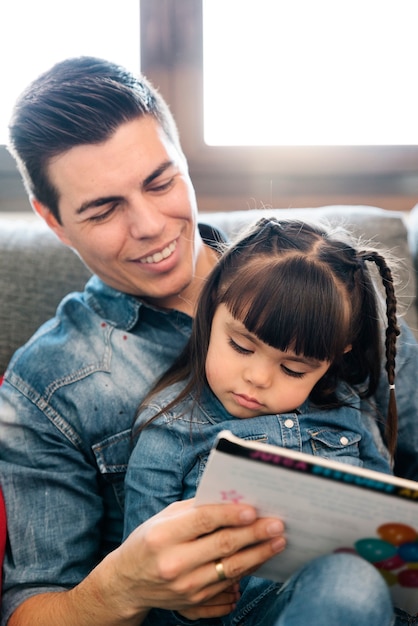 Vader leest thuis een boek voor aan haar dochter.