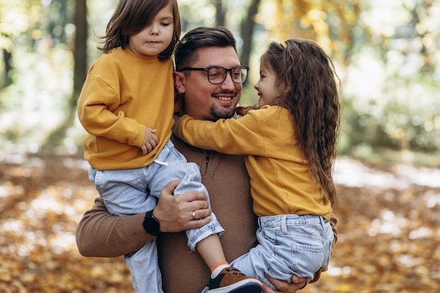 Vader met dochters die plezier hebben in herfstpark