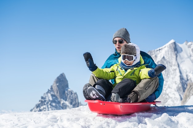 Vader met zoon rodelen