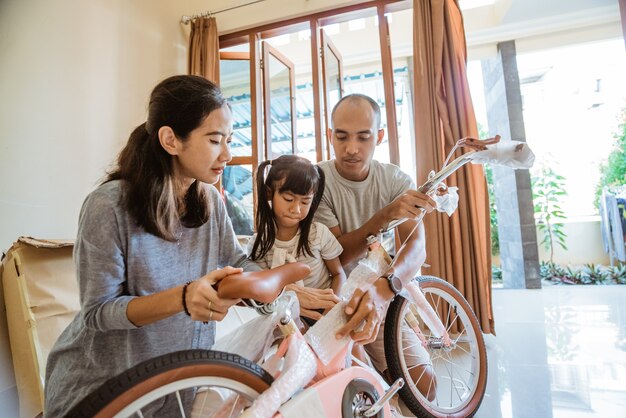 Vader moeder en dochter pakken een nieuwe minifiets uit