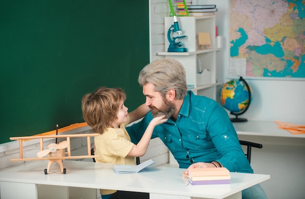 Vader onderwijst zoon ondersteunt leerlingen op school onderwijs achtergrond basisschool tutoring