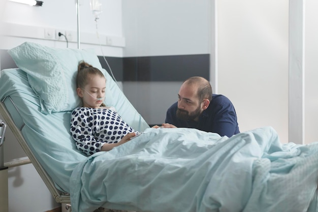 Foto vader praat met dochter in het ziekenhuis