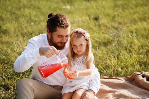 Vader schenkt sap aan dochter zomerpicknick