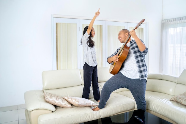 Vader speelt gitaar en danst met zijn dochter