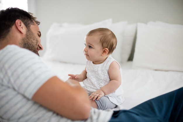 Vader spelen met zijn babymeisje in de slaapkamer thuis