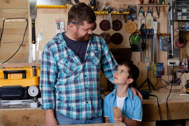 Vader timmerman en zoon jongen werken in de werkplaats Meester vader leert zijn zoon timmeren Continuïteit