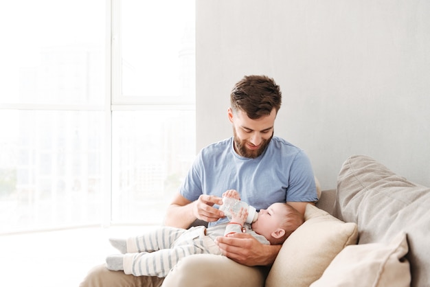 Vader voedt haar baby met een fles melk