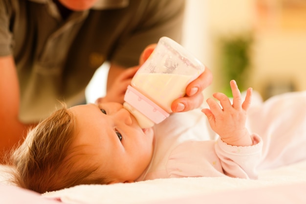 Vader voedt zijn baby met een fles; zeer rustige scène