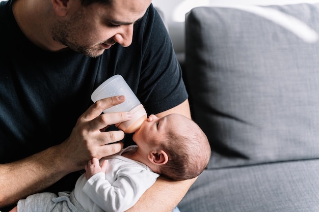 Vader voedt zijn kleine baby met een fles