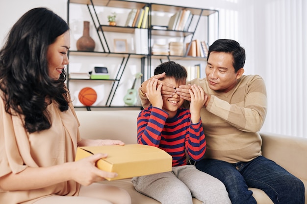 Vader voor ogen van preteen zoon wanneer moeder hem verjaardagscadeau geeft