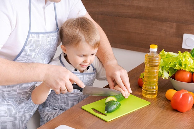 Vader zoon bereiden verse groenten in de keuken Vader en jongenskind gesneden