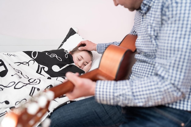 Vader zorgt voor zijn zieke dochter vaderlijke liefde kinderopvang een man met een gitaar