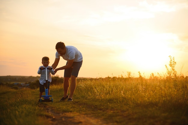 Vaderdag Gelukkige familie vader en peuter zoon spelen en lachen op de natuur bij zonsondergang