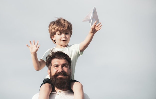 Vaders dag gelukkige familie vader en zoon op weide met een speelgoed papieren vliegtuigje in de zomer op de na
