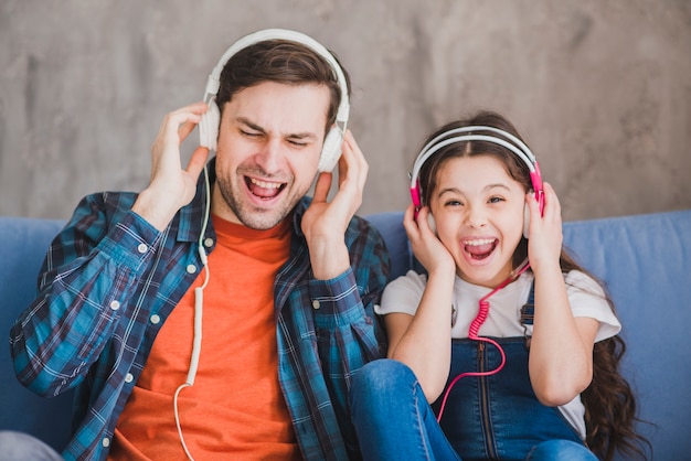 Foto vaders dagconcept met vader en dochter die aan muziek luisteren