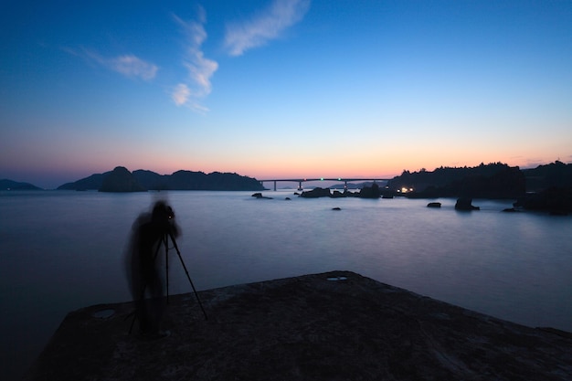 Vage figuur van een toerist met een camera op een zonsondergang