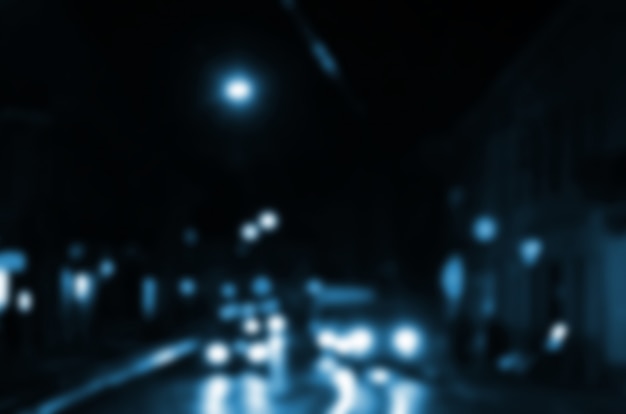 Vage nachtscène van verkeer op de rijweg. Defocused beeld van auto&#39;s die reizen met lichtgevende koplampen.