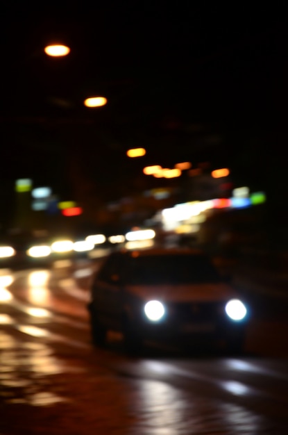 Vage nachtscène van verkeer op de rijweg.