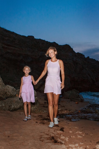 Vakantie aan zee. een gezin loopt langs het strand. familie hand in hand