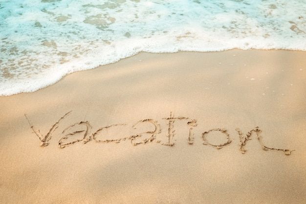 Foto vakantie bericht hand schrijven op het zandstrand