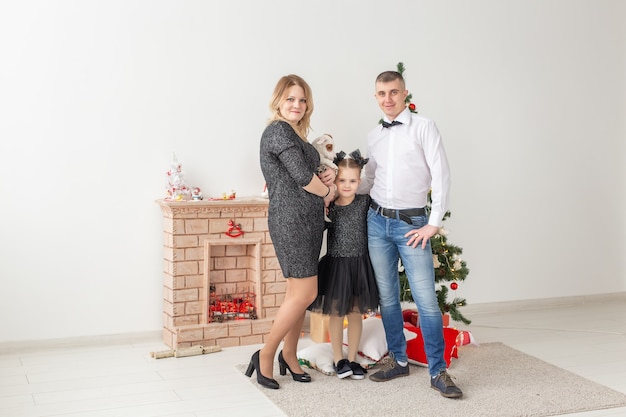 Vakantie concept - gelukkige familie moeder vader en kind bij kerstboom thuis.
