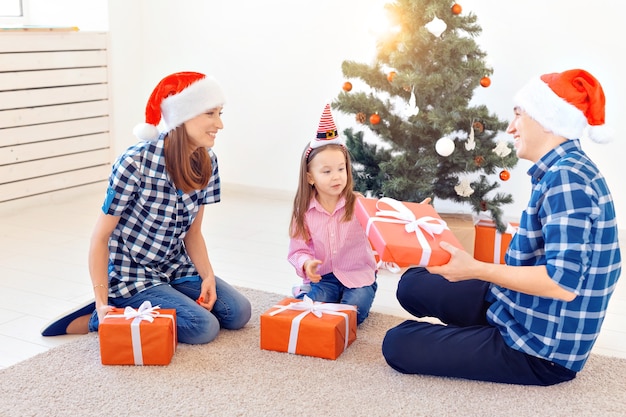 Vakantie en cadeautjes concept - portret van een gelukkige familie die geschenken opent met Kerstmis.