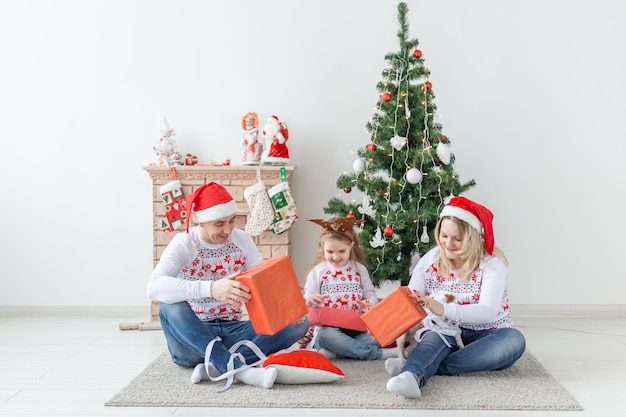 Vakantie en cadeautjes concept - portret van een gelukkige familie die geschenken opent met Kerstmis.