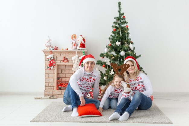 Vakantie en feestelijk concept - gelukkig familieportret door kerstboom.