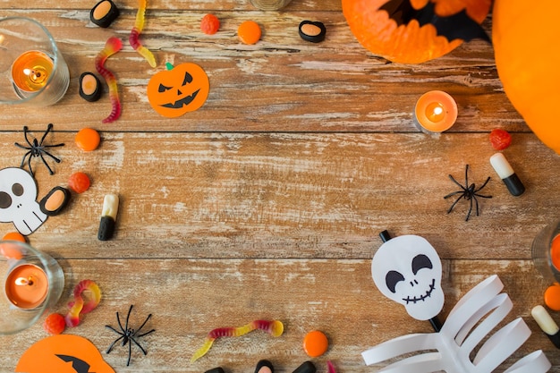 vakantie- en reclameconcept - halloweendecoraties en snoepjes met kopieerruimte op houten planken