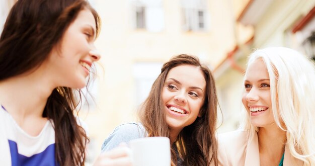 vakantie en toerisme concept - mooie meisjes die koffie drinken in café