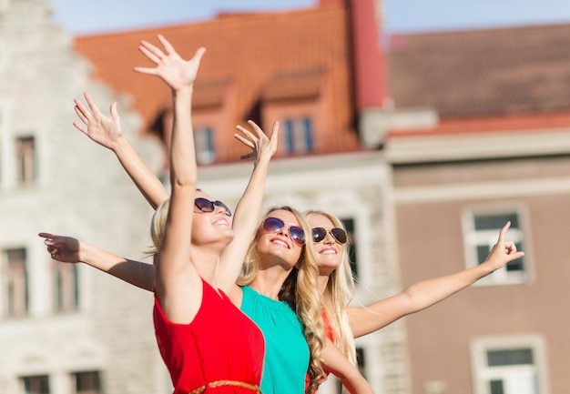 vakantie en toerisme, vrienden, vrijgezellenfeest, concept van blonde meisjes - drie mooie vrouwen in de stad die met de hand zwaaien