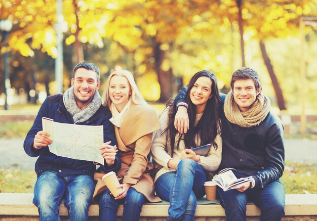 vakantie- en toerismeconcept - groep vrienden of koppels met toeristische kaart in herfstpark