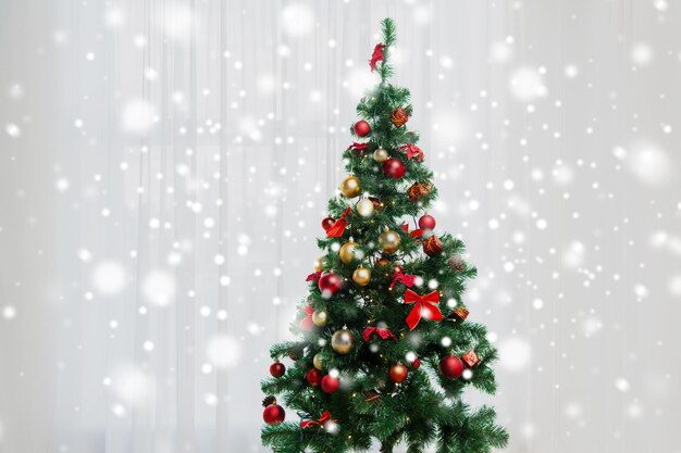 vakantie, feest en thuisconcept - kerstboom in woonkamer boven raamgordijn