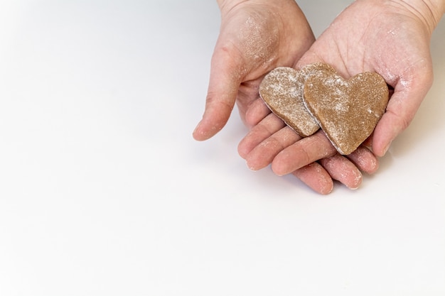 Vakantie gemberkoekjes in de vorm van hart in vrouwenpalmen