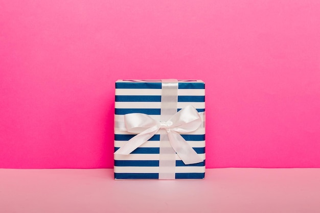 Vakantie handgemaakt cadeau gebonden roze lint boog bovenaanzicht met kopie ruimte Plat lag vakantie achtergrond Verjaardag of kerstcadeau Kerstcadeau box concept met kopie ruimte